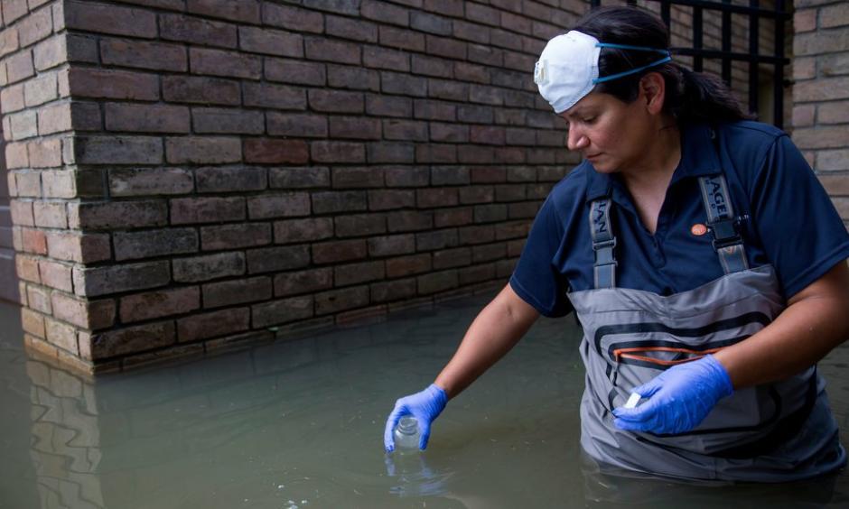 A woman collected water samples in September in a Houston neighborhood affected by flooding from Hurricane Harvey. Photo: Eric Thayer for The New York Times