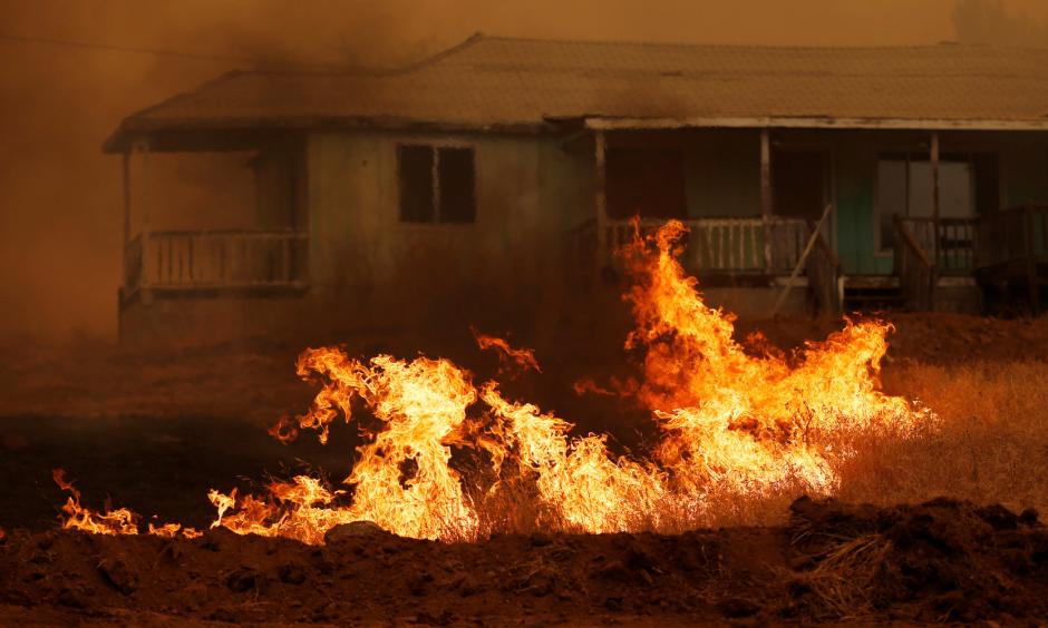 Grass burns in front of a home during the Detwiler fire in California, on July 19. Photo: Stephen Lam, Reuters