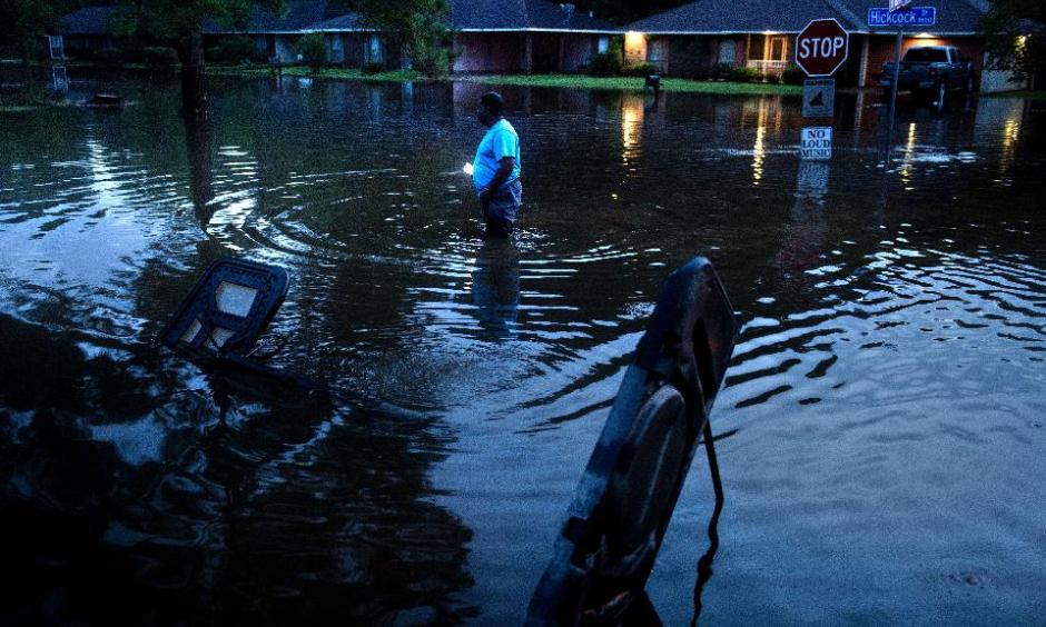 Tracy Thornton walks to his house through a flooded neighborhood August 15, 2016 in Baton Rouge, Louisiana.Floods ravaged the US state of Louisiana. Photo: Brendan Smialowski, AFP, Getty Images