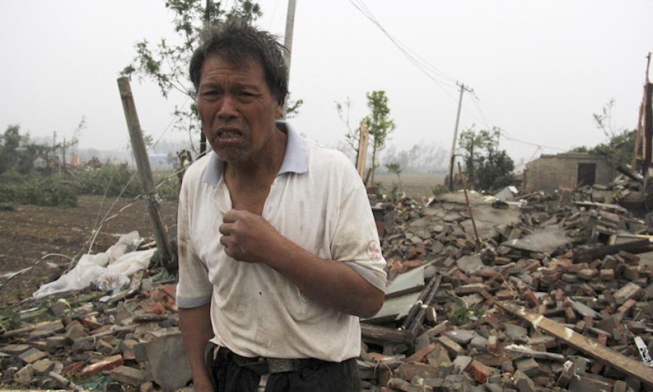 A villager stands near houses destroyed in the aftermath of a tornado that hit Funing county in Yancheng city in eastern China's Jiangsu Province on Thursday, June 23, 2016. Photo: Color China Photo via AP