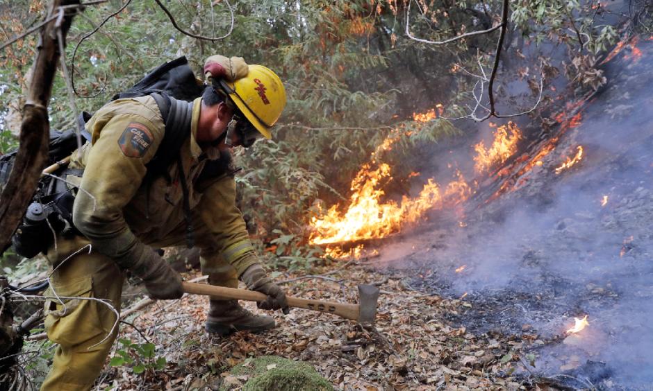 A firefighter builds a containment line as he battles a wildfire Tuesday, Oct. 17, 2017, near Boulder Creek, California. Photo: Marcio Jose Sanchez, AP