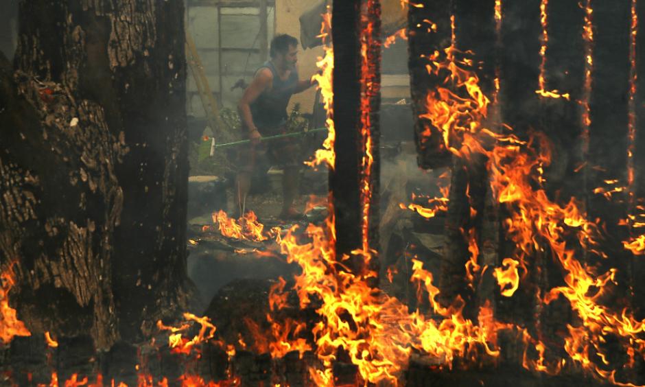 A resident tried to save his home in Glen Ellen, California, as the powerful winds blew burning embers. The hot summer created conditions ripe for fueling wildfires. Photo: Justin Sullivan, Getty Images