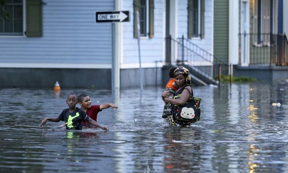 This Saturday, Aug. 5, 2017 photo shows a woman carrying an infant through floodwaters as two boys tag along in Metairie, La. Photo: Michael DeMocker, NOLA.com/The Times-Picayune via AP
