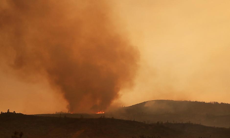Resident Moe Blythe watches the Holy Fire burn near homes on August 9, 2018 in Corona, California. Photo: Mario Tama, Getty Images