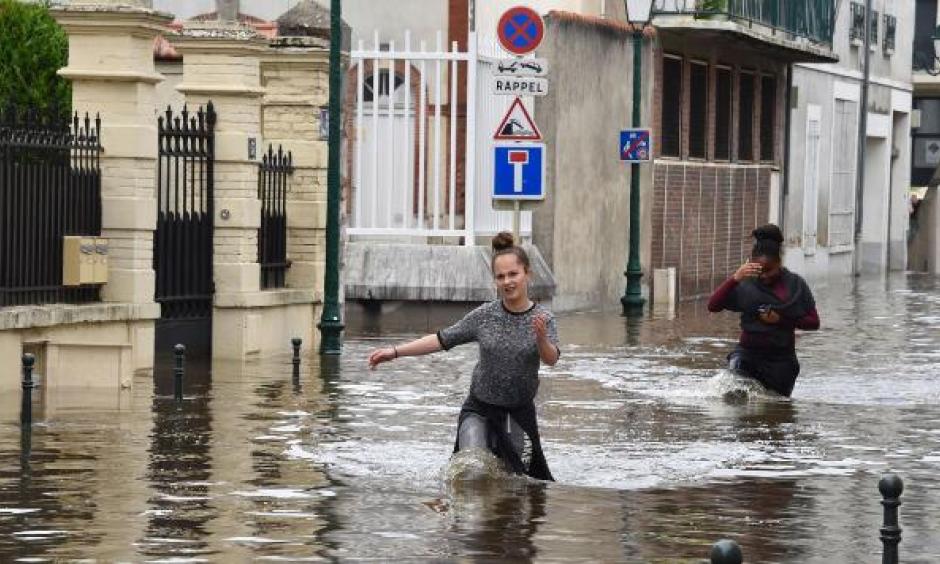Two women walk through the flooded streets of Montargis, France, south of Paris, on June 1, 2016. Photo: Dominique Faget, AFP, Getty Iamges