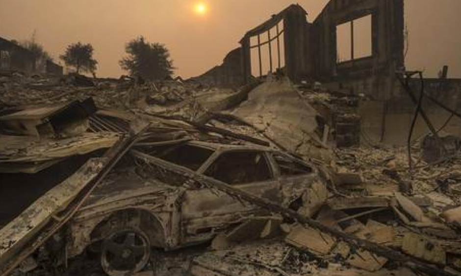 The sun rises through a cloud of smoke in the Rincon Ridge area after a Sonoma County wildfire on Tuesday October 10, 2017 in Santa Rosa, Calif. Scientists say climate change is producing more intense heat waves, like those seen this summer in California, drying out vegetation and adding to the risk of explosive blazes. Photo: Paul Kitagaki Jr.