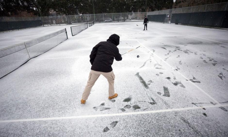 Vincent Sottile, center, and his brother Mike Sottile play hockey on the public tennis courts at Forsyth Park on Wednesday in Savannah, Ga. Photo: Stephen B. Morton, AP