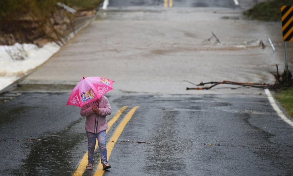A girl walks near a flooded street in Austin, Texas, on October 24, 2015. Photographer: Jewel Samad/AFP via Getty Images