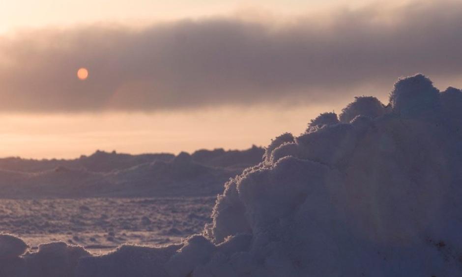 The sun sets over sea ice on the Chukchi Sea near Barrow, Alaska. This archival photo was taken in spring during the OASIS (Ocean_Atmosphere_Sea Ice_Snowpack) field project. Photo: UCAR Digital Image Library