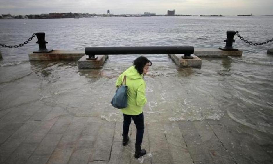 Lynda DeBiccari waded in as the water rose during a King tide at the end of Long Wharf. Photo: Lane Turner