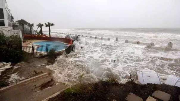 Waves crash over an experimental sea wall to protect homes during high tide on the Isle of Palms. Photo: AP