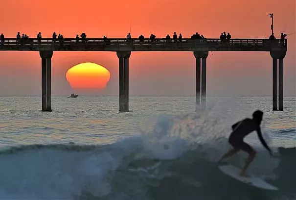 A surfer attempts to beat the heat in San Diego on Sunday. Credit: Jim Grant via Twitter