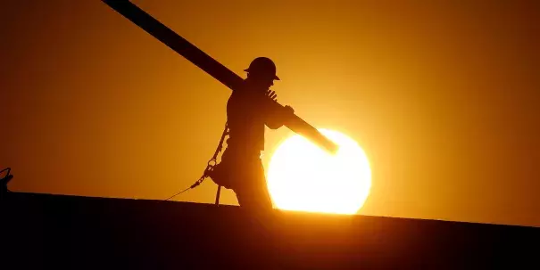 A home builder works at sunrise on Monday in Gilbert, Arizona, in an effort to beat the rising temperatures. Photo: AP