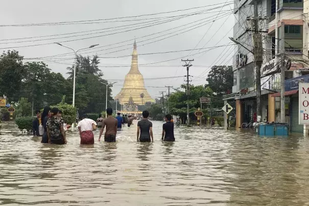 Local residents wade through a flooded road near Shwe Maw pagoda in Bay, about 50km northeast of Yangon, Myanmar, Monday, Oct. 9, 2023. (Credit: AP Photo/Thein Zaw)