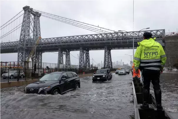 A police officer from the NYPD Highway Patrol looks on as motorists drive through a flooded street after heavy rains as the remnants of Tropical Storm Ophelia bring flooding across the mid-Atlantic and Northeast, at the FDR Drive in Manhattan near the Williamsburg Bridge, in New York City, U.S., September 29, 2023. (Credit: Reuters/Andrew Kelly/File Photo)