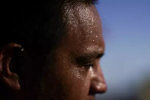 FILE - Sweat covers the face of Juan Carlos Bison as afternoon temperatures reach 115 degrees Fahrenheit, July 19, 2023, in Calexo, California. (Credit: AP Photo/Gregory Bull, File)