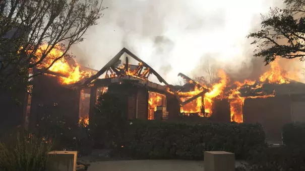 Flames from a wildfire consume a home Monday, east of Napa, Calif. Photo: Rich Pedroncelli, AP