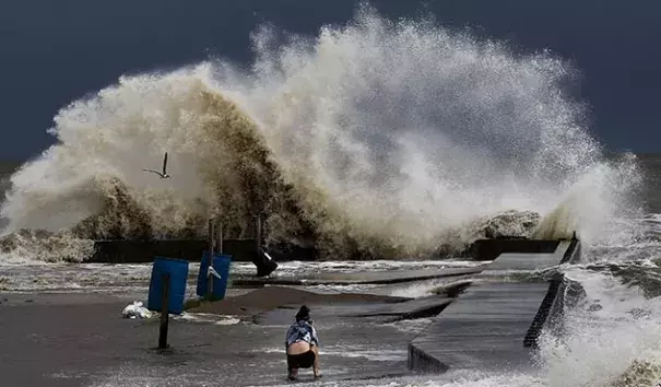 Sydney Schultz takes photos of waves crashing next to Rollover Pass as Tropical Storm Cindy approaches the coast Wednesday, June 21, 2017 on the Bolivar Peninsula, Texas. Photo: Michael Ciaglo, Houston Chronicle via AP