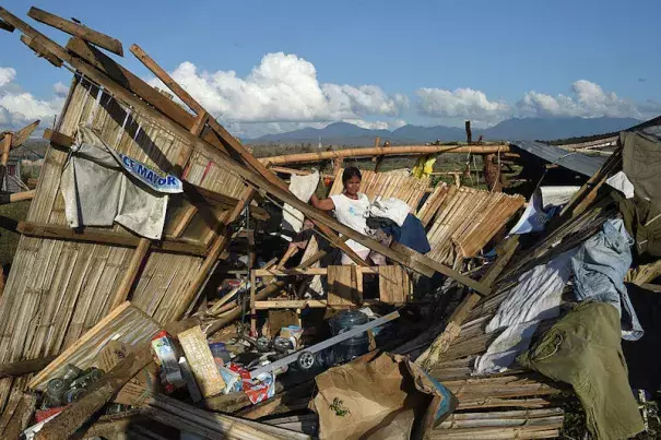 A resident of a home destroyed at the height of Typhoon Haima in Cabagan town, Isabela province, north of Manila on October 21, 2016. Cabagan and nearby areas on the east side of coastal mountains took the hardest hit from Hamia’s Category 4 winds. Image: Ted Aljibe/AFP/Getty Images