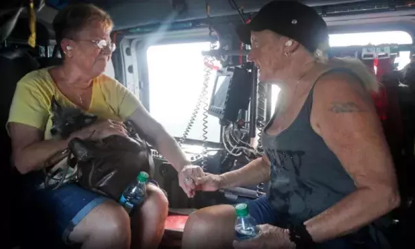 Wanda McGhee, left comforts Leann Davis in a Coast Guard helicopter after they were picked up from their flooded homes in Burgow, NC., Tuesday, Sept. 18, 2018. . Photo: Steve Helber, AP
