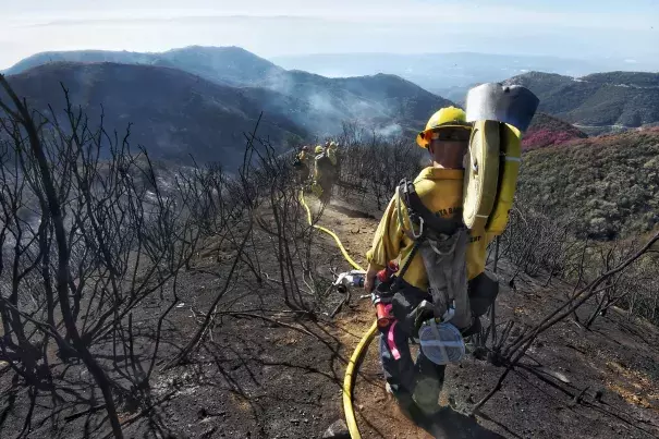 Santa Barbara County Firefighters haul dozens of pounds of hose and equipment down steep terrain to root out and extinguish smoldering hot spots in Santa Barbara on Tuesday, Dec. 19, 2017. Officials estimate that the Thomas Fire will grow to become the biggest in California history before full containment. Photo: Mike Eliason, AP