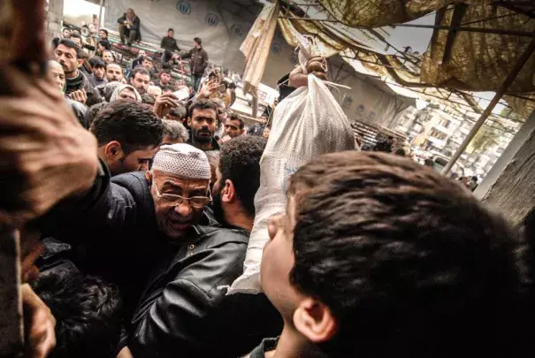 Aleppo residents clamor for aid at food distribution point of the UN World Food Program, February 2013. Photo: Jan-Niklas Kniewel,EPA