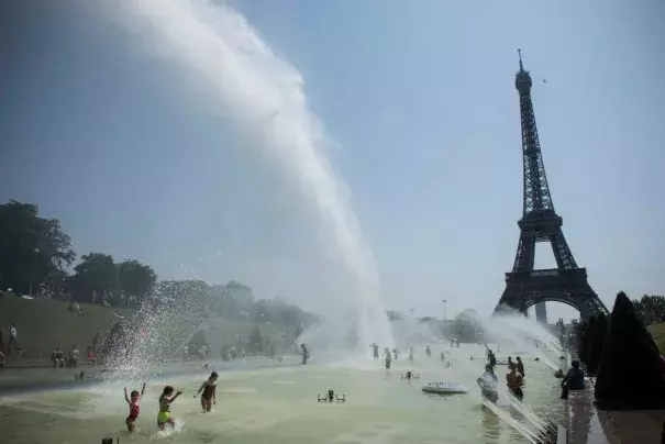Cooling down at the fountains of Trocadero, near the Eiffel Tower, on a day of record heat in Paris on July 25. Photo: Julien De Rosa, EPA-EFE/Shutterstock
