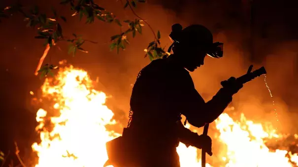 Cal Fire firefighter Trevor Smith battles the Tubbs Fire near Calistoga, Calif., on Thursday. Wildfires in Northern California have killed dozens of people and destroyed thousands of homes and businesses. Credit: Justin Sullivan, Getty Images