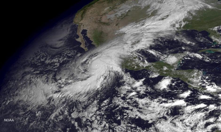 A handout satellite image made at 10:45 am ET and released by the US National Oceanic and Atmospheric Administration (NOAA) on 23 Oct. 2015 shows Hurricane Patricia (L) as it approaches the coastline of Mexico from the Eastern Pacific. Image: EPA / NOAA / HANDOUT