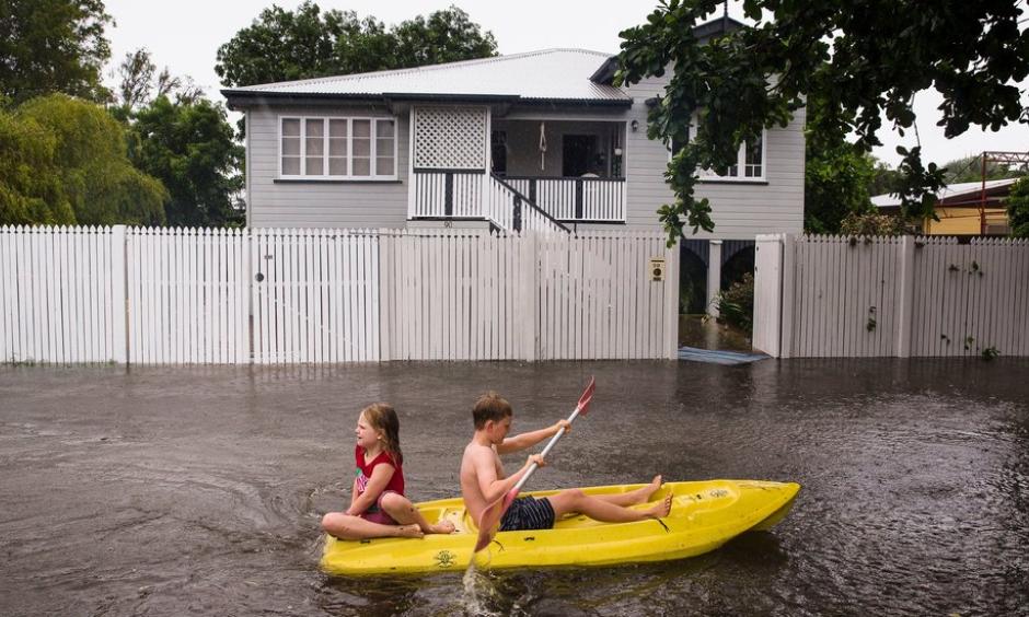 Residents paddling down a street in Townsville, Australia, on Saturday. “In seven days, we’ve received our annual total rainfall,” the mayor said. Photo: Andrew Rankin, EPA, via Shutterstock