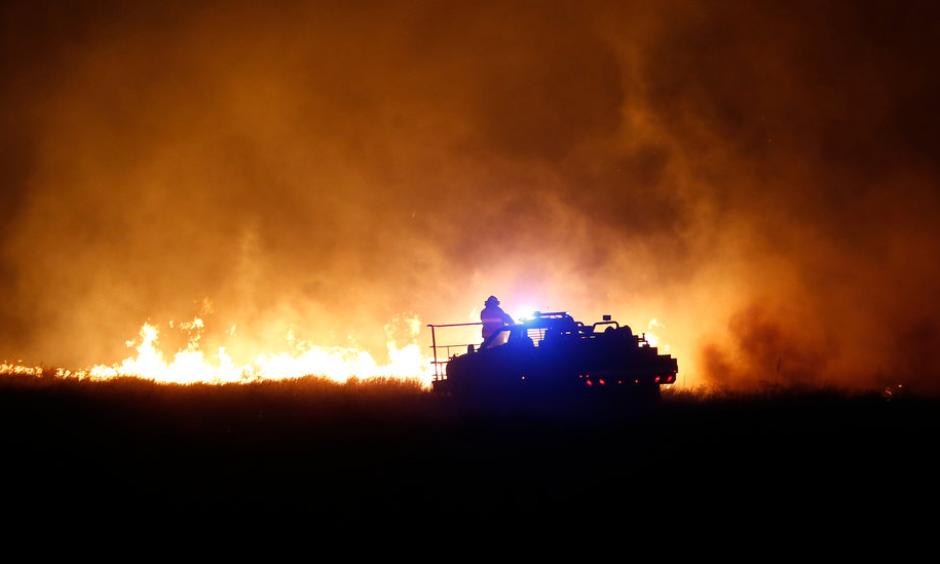 Firefighters near Protection, Kan., this week. Dry conditions have helped fuel the flames. Photo: Credit Bo Rader, The Wichita Eagle, via Associated Press