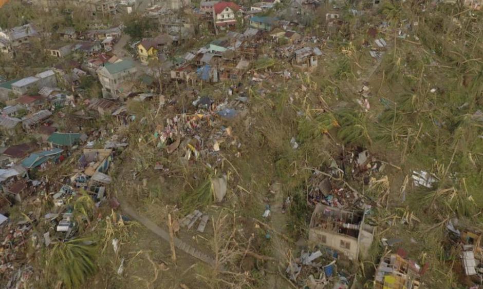 In this photo provided by the Philippine Navy, damaged houses and toppled trees lie in Dinagat Island, Surigao del Norte province, southern Philippines on Friday, Dec. 17, 2021. The governor of an island province in the central Philippines said dozens of people died in the devastation wrought by Typhoon Rai in just half of the towns that managed to contact him, bringing the death toll in the strongest typhoon to batter the country this year to nearly 100. (Philippine Navy via AP)