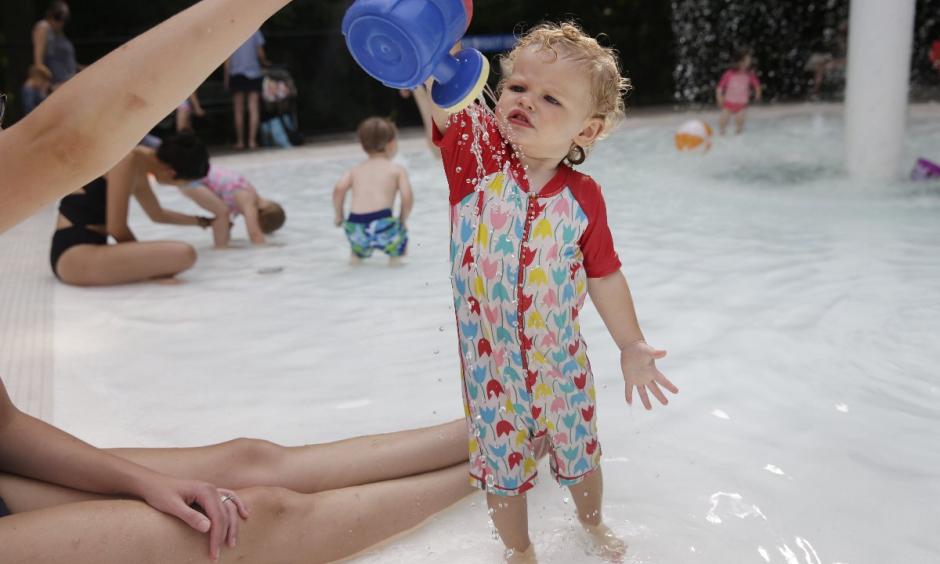 Ava Owens gets a cool shower from her mom Laura Owens at a pool in Hasting-on-Hudson, N.Y. Photo: Seth Wenig, AP