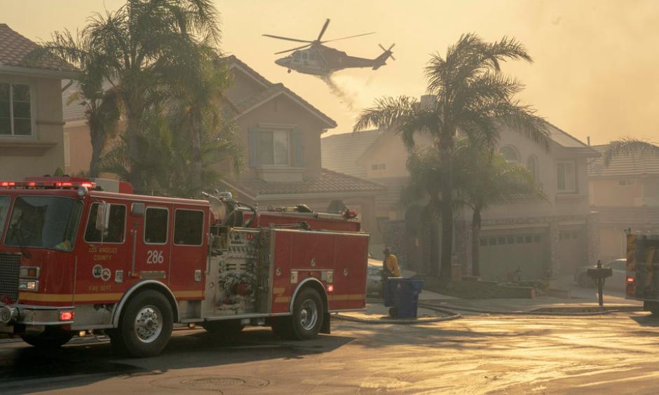 A helicopter dropped water onto a burning hillside in the Porter Ranch neighborhood. Credit: Kyle Grillot, The New York Times