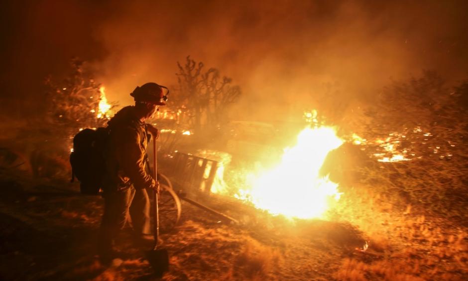 A firefighter watches the Blue Cut wildfire burning near Cajon Pass, north of San Bernardino, California on August 16, 2016. Photo: Ringo Chiu, AFP, Getty