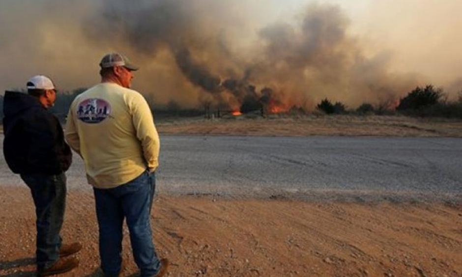 Jeff Clark and Roger Van Rankin watch the fire east of Lake City, Kan., Wednesday, March 23, 2016. Photo: AP