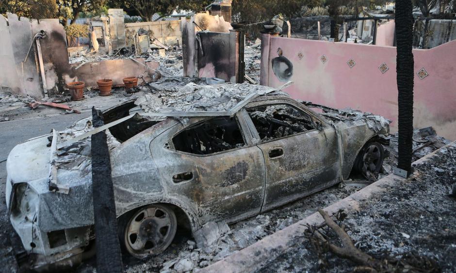 The remains of a destroyed car stand infront of a destroyed home in the aftermath of the Holiday Fire on July 7, 2018 in Goleta, California. Credit: Mario Tama, Getty Images