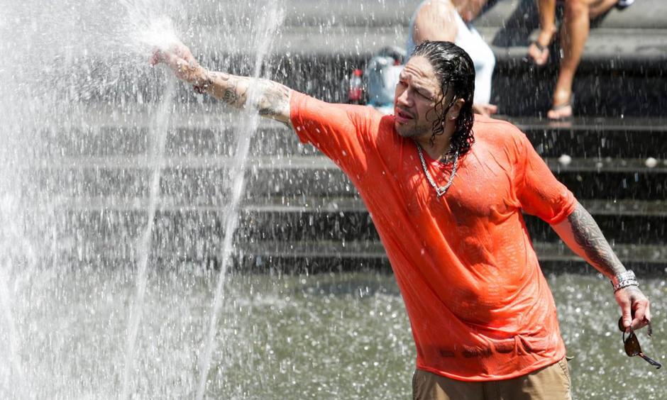 A man cools off himself in a fountain during a heat wave in New York City on July 23, 2016. Photo: Eduardo Munoz / Reuters
