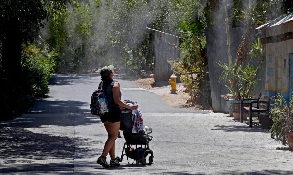 A visitor to the Phoenix Zoo walked through misting water on Tuesday. Credit: Matt York, Associated Press