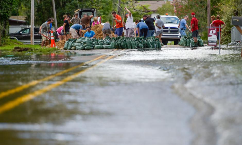 Volunteers pitched in to help residents fill sand bags against flooding from the Vermilion River in Lafayette, La., on Monday. Photo: Scott Clause/The Daily Advertiser, via Associated Press