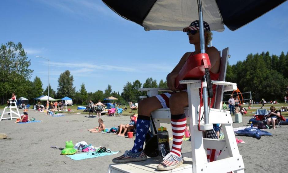 Lifeguard Luke Orot watches over swimmers at Jewel Lake on a hot July 4 in Anchorage. Photo: Lance King, Getty Images