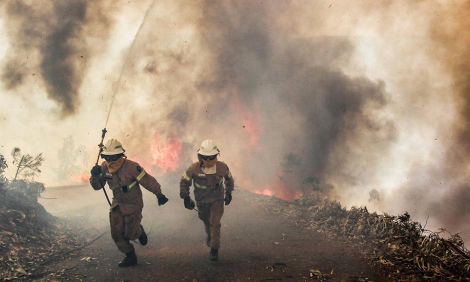 Flames and smoke cut off roads on Sunday in Capela Sao Neitel, in central Portugal, where members of the National Guard tried to contain several forest fires. Photo: Paulo Cunha, European Pressphoto Agency