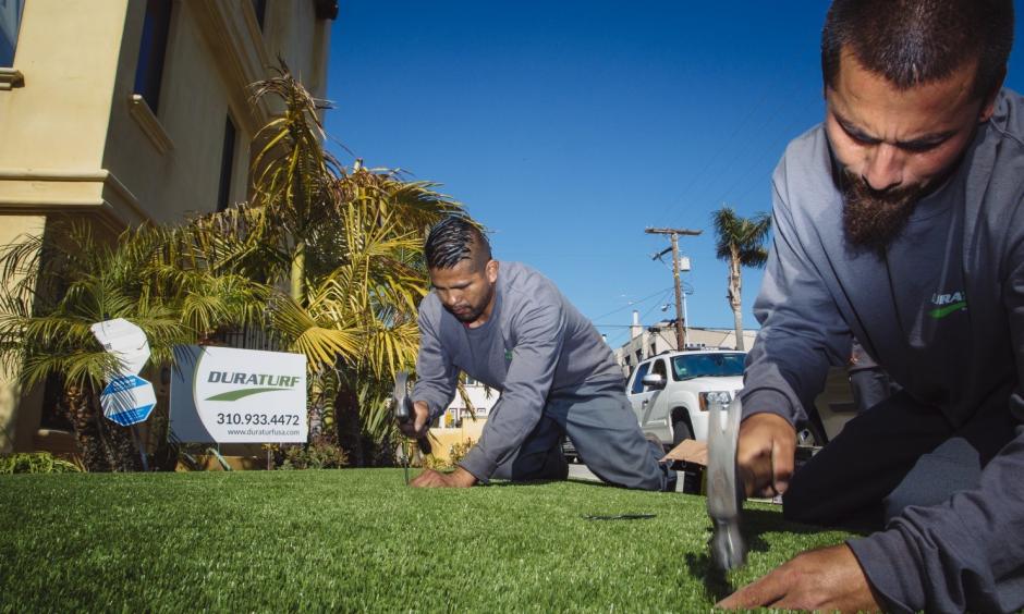 Workers from DuraTurf work on final touches with the artificial lawn at the home of Christopher Knight, who had the turf installed because of California's drought. Photo: David Walter Banks, Washington Post