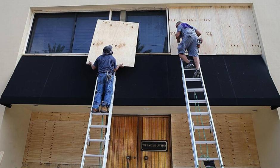 Workers Victor Briones and Dennis Flores board up the Haggard Law offices windows in Coral Gables on September 07, 2017 as South Florida prepares for the coming hurricane Irma. Photo: Pedro Portal