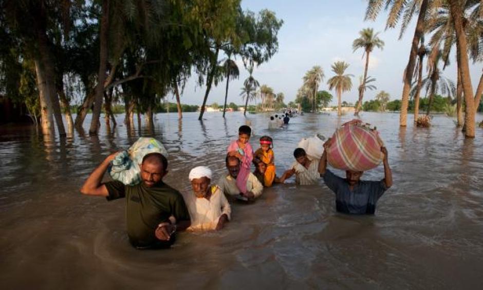 A family leaves flooded Baseera, Pakistan, this week. Photo: Adrees Latif, Reuters