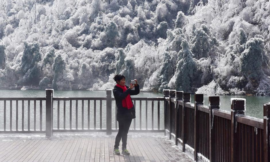 A woman photographs the scene at Hangzhou, in eastern China’s Zhejiang province. In Inner Mongolia, the temperature fell to a record low of -46.8C (-52F). Photo: AFP, Getty