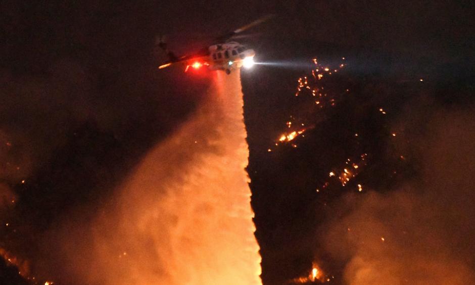 Thousands have been forced to evacuate their homes as a wildfire threatens the Santa Clarita Valley, north of Los Angeles. A resident describes being evacuated as firefighters worked to save his neighborhood. Photo by Ringo H.W. Chiu/Associated Press.