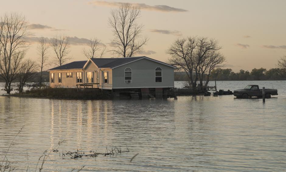 A home is surrounded by floodwaters in Bartlett, Iowa. Credit: Nati HarnikAP