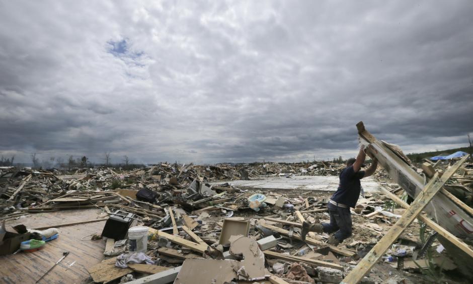 In this April 30, 2014, file photo, Dustin Shaw lifts debris as he searches through what is left of his sister's house at Parkwood Meadows neighborhood after a tornado in Vilonia, Ark. A new study finds that tornado activity is generally shifting eastward to areas just east of the Mississippi River that are more vulnerable such as Mississippi, Arkansas and Tennessee. And it's going down in Oklahoma, Kansas and Texas. Photo: Danny Johnston, AP