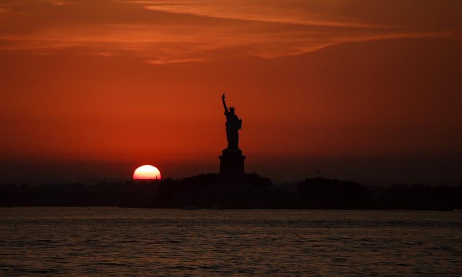 In this July 1, 2018 file photo, the sun sets behind the Statue of Liberty in New York as record high temperatures were recorded over the week in the U.S. and elsewhere. An AP data analysis of records from 1999-2019 shows that in weather stations across America, hot records are being set twice as often as cold ones. Photo: Andres Kudacki, AP
